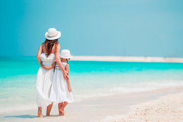 Fototapeta na wymiar Beautiful mother and daughter at the beach enjoying summer vacation.
