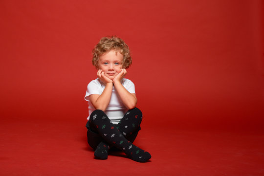 boy posing on a red background in the studio. 