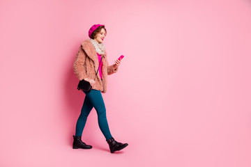 Full body profile side photo positive cheerful girl blogger go walk use smart phone type social media message news wear dotted jumper blue pants trousersisolated pink color background