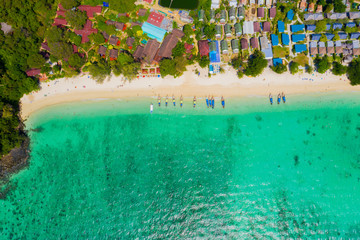 Fototapeta na wymiar View from above, stunning aerial view of a beautiful tropical beach with white sand and turquoise clear water, long-tail boat and people sunbathing,Long beach, Phi Phi Thailand.