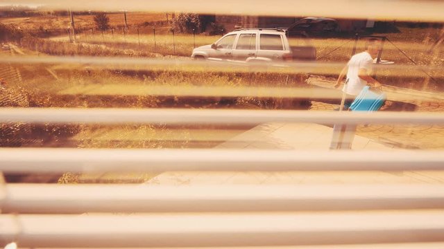 Strong Man Puts Suitcases Into The Car Boot. He Is Carrying By A Large And Huge Suitcase. View From Shutters. Close Up. Copy Space. 4K.