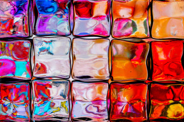 Abstract background of a colorful image distorted through a glass block wall