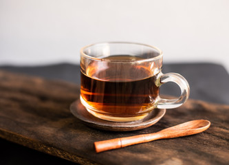 Hot tea with spoon wood on woo table.