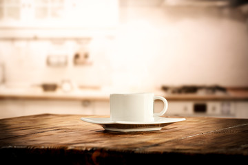 Table background in kitchen interior and woman hands with cup of coffee 