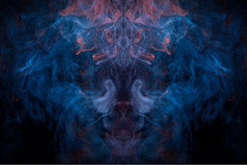 Fantasy print for clothes: t-shirts, sweatshirts.  Colorful blue and orange  smoke in the form of a skull, monster, dragon on a black isolated background. Background from the smoke of vape.