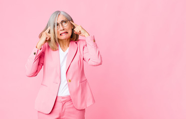 middle age cool woman looking concentrated and thinking hard on an idea, imagining a solution to a...