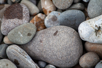 Fototapeta na wymiar sea pebbles colored granite on the beach background stones.
