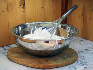 Using an egg beater or hand whisk beats the egg whites in the metal mixing bowl until frothy or soft peak.
