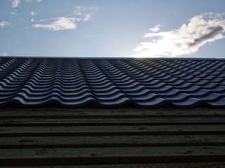 laying metal tiles on a rural house, Russia