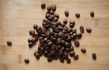 Coffee beans are on wooden desk. Flat lay, top view