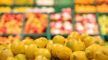 Colorful Display Of Lemons in a basket at bio market or grocery store. Organic Fresh lemons background close up