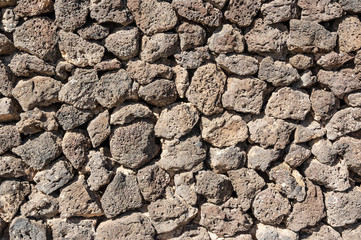 Texture of stone wall made of volcanic rocks