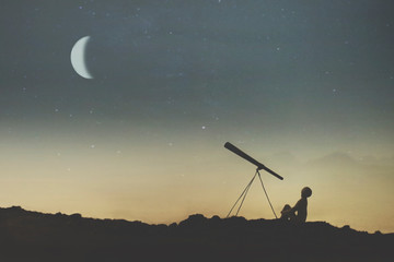 silhouette of a boy observing the sky on a starry night with his telescope