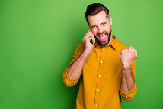 Close-up portrait of nice attractive cheerful cheery glad satisfied guy in formal shirt discussing great news on cell isolated on bright vivid shine vibrant green color background
