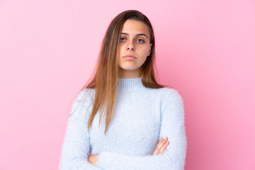 Teenager girl with blue sweater over isolated pink background keeping arms crossed