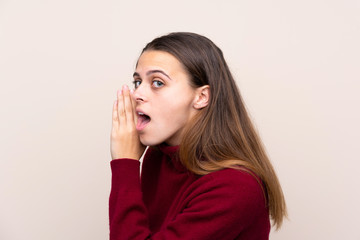 Teenager girl over isolated background whispering something