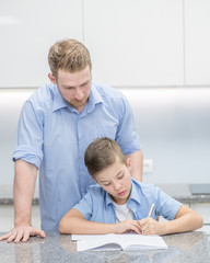 Fototapeta premium Father helps his son doing homework at home