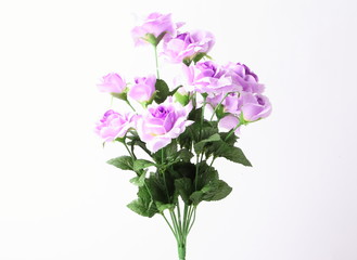 Obraz na płótnie Canvas Artificial violet roses on white background