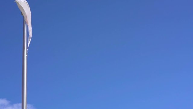 Raw 120fps slow motion video of the Japanese National Flag waving in the wind against a cloudless blue sky in Japan where Tokyo is the host city for the international sporting events in summer 2020.