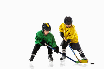 Plakat Little hockey players with the sticks on ice court and white studio background. Sportsboys wearing equipment and helmet practicing. Concept of sport, healthy lifestyle, motion, movement, action.