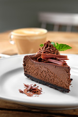Close up view of piece of chocolate cake with cappuccino