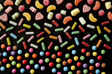 Rainbow colored assorted sweets on black