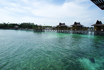 houses on the water against the turquoise sea and cloudy sky