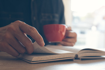 Man reading book drinking coffee