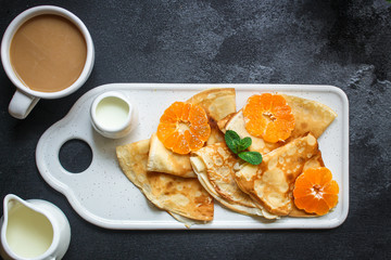 crepes with citrus, jam and berries (thin pancakes, mandarin, blueberry) menu concept. background. top view. copy space