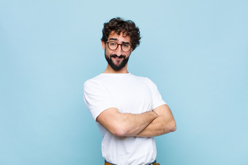 young bearded man with glasses against blue wall