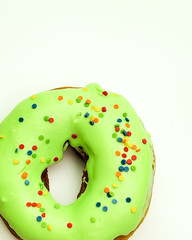 Donut with green glaze on white background top view.