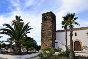 Fototapeta na wymiar Church of Our Lady of Candelaria (Church of Nuestra Senora de la Candelaria) located in La Oliva, Fuerteventura, Spain. A 16th century church with a volcanic stone tower