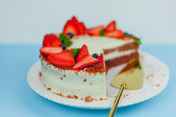 Beautiful cake with berries with butter cream on a blue background. Cake with red cakes.