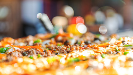 Close-up fresh tasty pizza blurred background with bokeh.