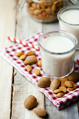 Fresh organic vegan almond milk. Alternative source of protein for vegetarians. Raw almonds as ingredients, peeled and unpeeled. Concept of healthy lifestyle. Closeup, wooden background