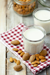 Fresh organic vegan almond milk. Alternative source of protein for vegetarians. Raw almonds as ingredients, peeled and unpeeled. Concept of healthy lifestyle. Closeup, wooden background, copy space