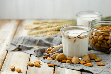 Fresh organic vegan almond milk. Alternative source of protein for vegetarians. Raw almonds as ingredients, peeled and unpeeled. Concept of healthy lifestyle. Closeup, wooden background