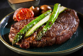 Thick juicy beef steak with green asparagus