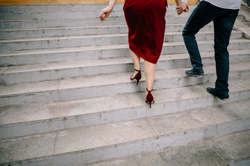 Beautiful young couple, a couple of students walk on the stairs in the city center.