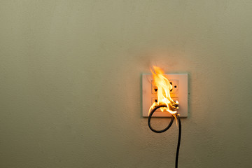 On fire electric wire plug in the receptacle at wall partition