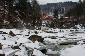 Fototapeta na wymiar View of the frozen Prut mountain river in the Carpathian village of Yaremche. Ukraine