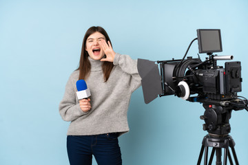 Young reporter woman holding a microphone and reporting news shouting with mouth wide open