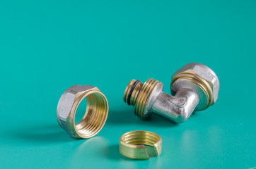 Disassembled The pipe compression fittings on a green background. Corner fitting for multilayer...