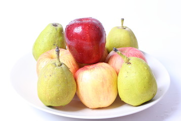 Apples and pears with water drops on white plate