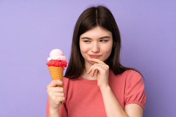 Young Ukrainian teenager girl holding a cornet ice cream over isolated purple background