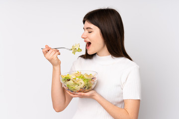 Young Ukrainian teenager girl holding a salad over isolated white background