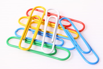 colorful paper clips over the white background