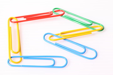 colorful paper clips over the white background