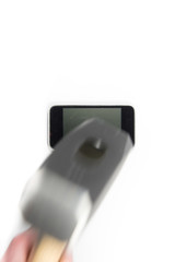 A smart phone laying horizontally is about to be hit with a sledgehammer. The sledgehammer is blurred by motion.