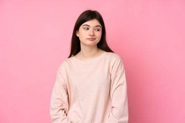Obraz premium Young Ukrainian teenager girl over isolated pink background making doubts gesture looking side